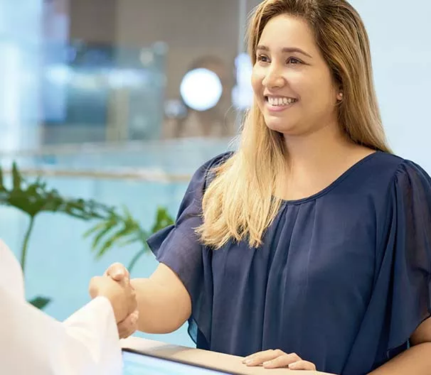 Woman shaking a person's hand.